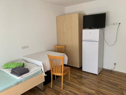 Habitación pequeña con cama y TV. en City Rooms, en Hohenems