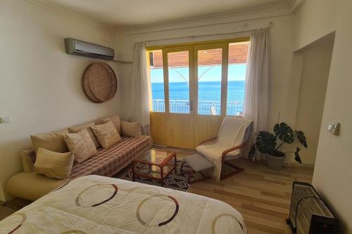 ein Schlafzimmer mit einem Bett und einer Couch und einem Fenster in der Unterkunft Uğrak Home in Işıklı