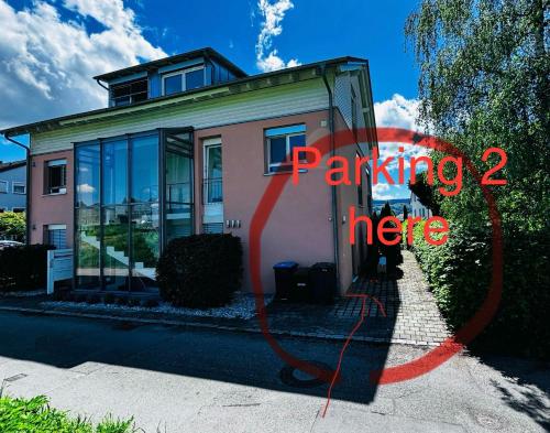 a house with a sign that reads parking here at Lakefront View Entire Apartment with 2 bedrooms, 2 full bathrooms & Balcony Waterview in Reichenau