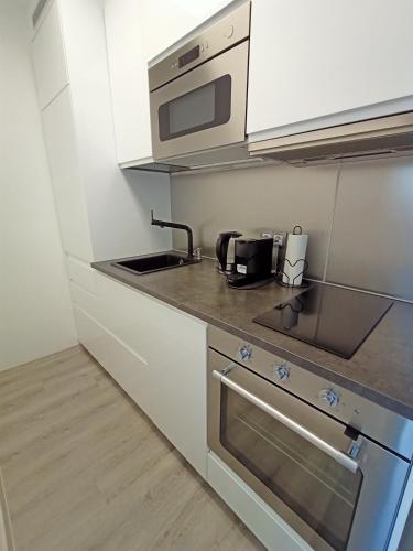 a kitchen with a sink and a microwave at Apartament Gliwice Centaura, dwa pokoje, klimatyzacja in Gliwice