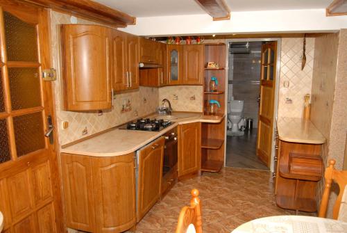 a kitchen with wooden cabinets and a stove top oven at Agroturystyka Sokolec Górski in Sokolec