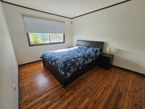sypialnia z łóżkiem i oknem oraz drewniane podłogi w obiekcie Entire 3 bedroom personal house in Chipping Norton w mieście Chipping Norton