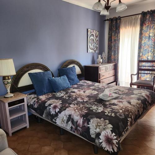 una camera da letto con un grande letto con pareti blu di Don Sidónio Alojamentos a Portimão