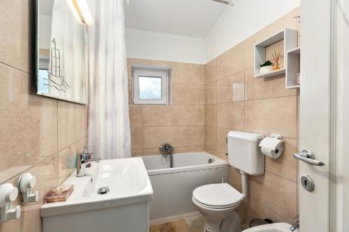a bathroom with a toilet and a sink and a tub at Apartman Tromba near the Sea in Šišan