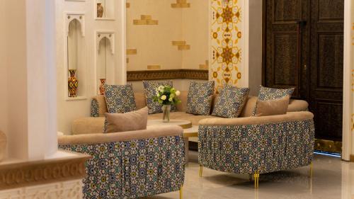 un soggiorno con divani, tavolo e fiori di Kohinur Plaza a Samarkand