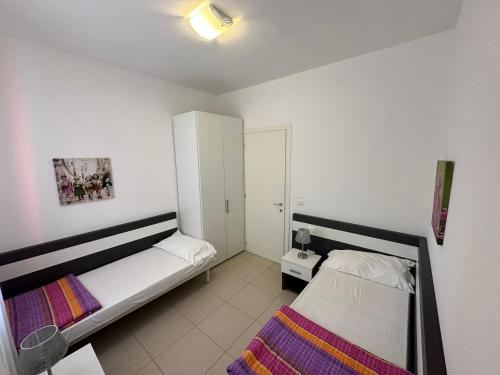 卡奧萊的住宿－Residence Orate - Agenzia Cocal，一间带两张床和橱柜的小卧室