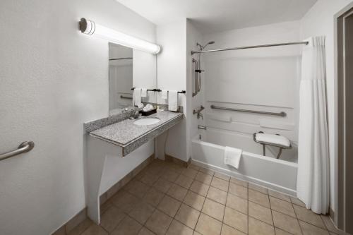 y baño con lavabo y ducha. en Super 8 by Wyndham Baton Rouge/I-10 en Baton Rouge