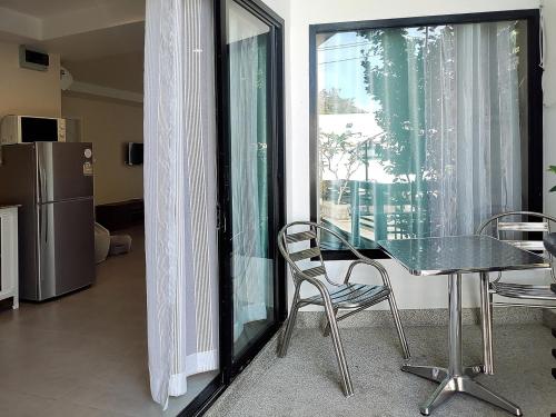 a glass table and chairs in a room with a window at Villa LunaSole Samui in Koh Samui 