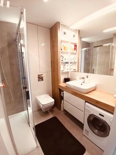 a bathroom with a sink and a washing machine at PRZY PLAŻY APARTAMENT 306 Porta Mare in Dziwnówek