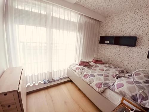 a bedroom with a bed and a large window at PRZY PLAŻY APARTAMENT 306 Porta Mare in Dziwnówek