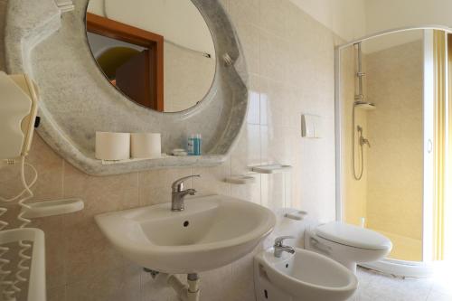 a bathroom with a sink and a mirror and a toilet at Nirvana Club Village in Botricello