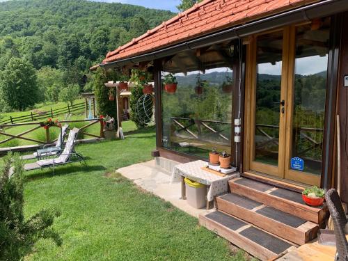 a house with a table and a bench in the grass at Apartmani Lunija in Gornji Milanovac