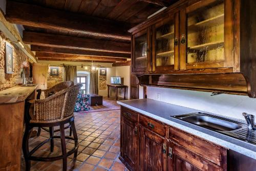 a kitchen with wooden cabinets and a sink at Barokni Spejchar in Tlučná
