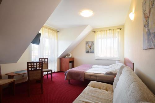 a bedroom with a bed and a table and a chair at Villa del Marco in Rewal