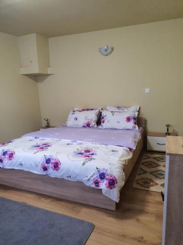 een slaapkamer met een bed met roze bloemen erop bij Carissa House in Braşov