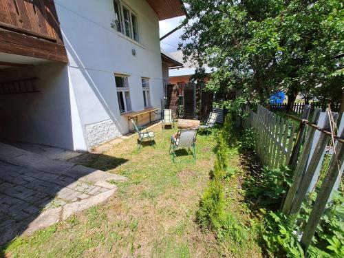 a yard with a fence and a chair next to a house at Chalupa u Dionýza in Rejdová