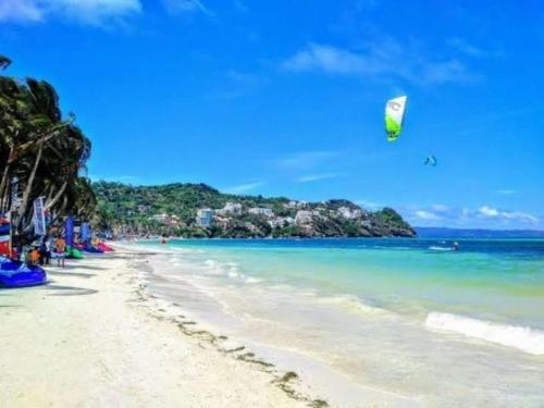 a beach with a kite flying over the ocean at La Oviedo Villas Resort Boracay in Boracay