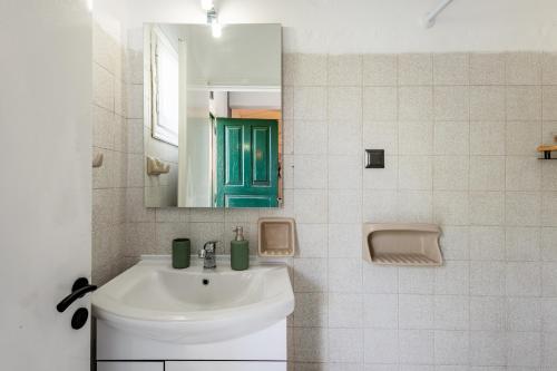 un bagno bianco con lavandino e specchio di Ilios Place Corfu-Near Old Town & Beaches a Kontokali