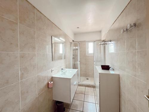 uma casa de banho com um lavatório branco e um chuveiro em Résidence Villa Romana avec spa em Propriano