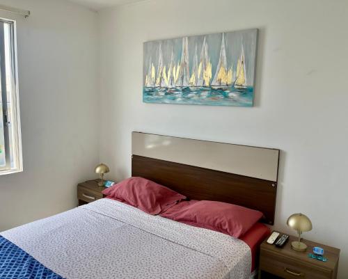 1 dormitorio con 1 cama con veleros en la pared en Suite 1ra Fila Vista Bahía - 100 Metros Las Velas 601 T1 en Paracas