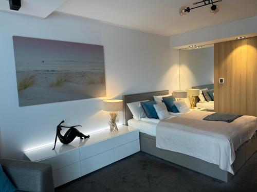 a bedroom with a large bed with a large painting on the wall at Seaside Luxury Apartament in Kołobrzeg
