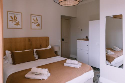 1 dormitorio con 1 cama con toallas en L'Orangeraie d'Afa, en Afa