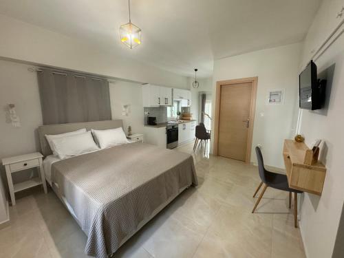 a bedroom with a bed and a desk and a kitchen at Moretti Studios in Gythio