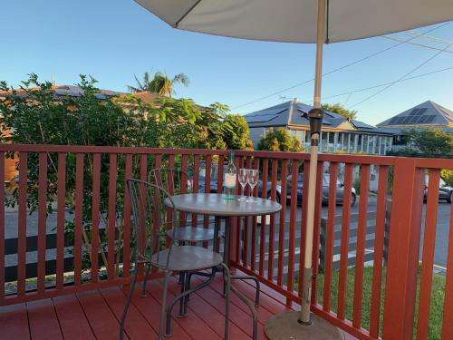 a table and chairs on a balcony with an umbrella at West End Studio 5 in Brisbane