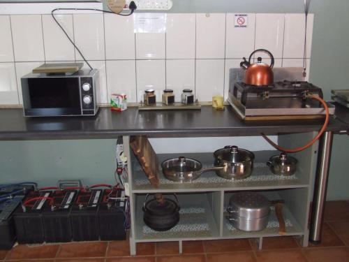 a kitchen with a microwave and some pots and pans at Eltos Karoo Stay Guest Farm in Laingsburg
