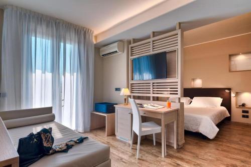 a hotel room with a bed and a desk and a bed and a couch at Hotel Terme Belsoggiorno in Abano Terme