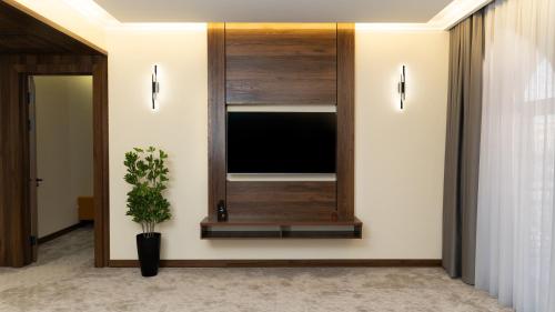 a living room with a flat screen tv on a wall at Kohinur Plaza in Samarkand