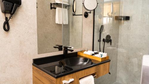 une salle de bain avec un lavabo et un miroir dans l'établissement Kohinur Plaza, à Samarcande