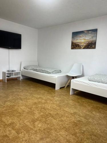 a room with two beds and a flat screen tv at Fewo Haus Ema in Lahr