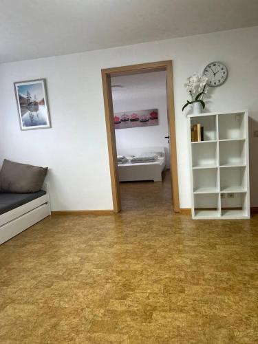 a living room with a couch and a clock on the wall at Fewo Haus Ema in Lahr