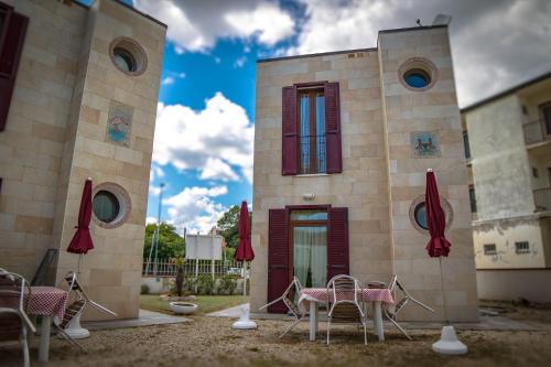 a building with chairs and umbrellas in front of it at Residence Eden in Comacchio