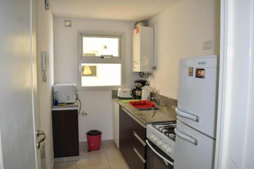 a kitchen with a white refrigerator and a stove at Baleine in Puerto Madryn