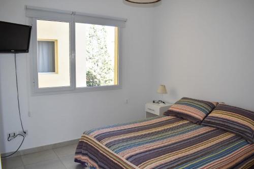 a bedroom with a bed and a window at Baleine in Puerto Madryn