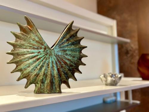 a bronze butterfly sculpture sitting on a shelf at Parisian Studios design by KENZO in Paris