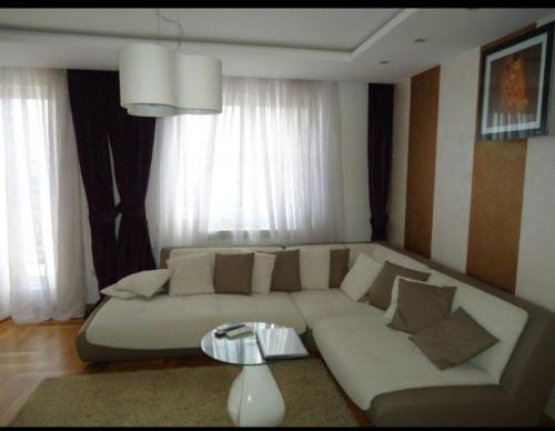a living room with a couch and a table at Lux Apartman 7 in Voždovac