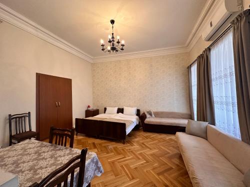 sypialnia z 2 łóżkami, kanapą i żyrandolem w obiekcie Apartment Dadiani 26 w mieście Tbilisi City