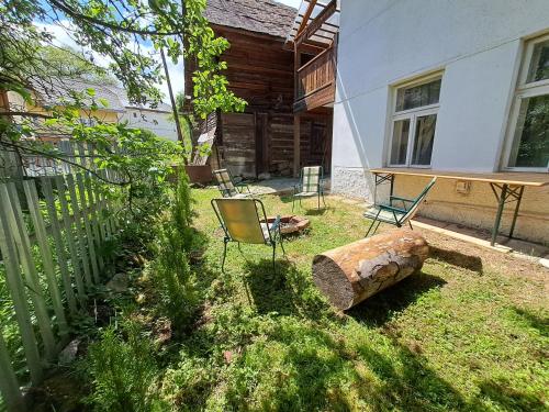 a yard with chairs and a fence and a log at Chalupa u Dionýza in Rejdová