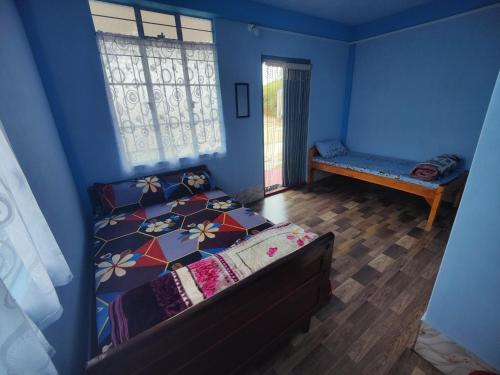a bedroom with a bed in a blue room at Iba Homestay in Cherrapunji