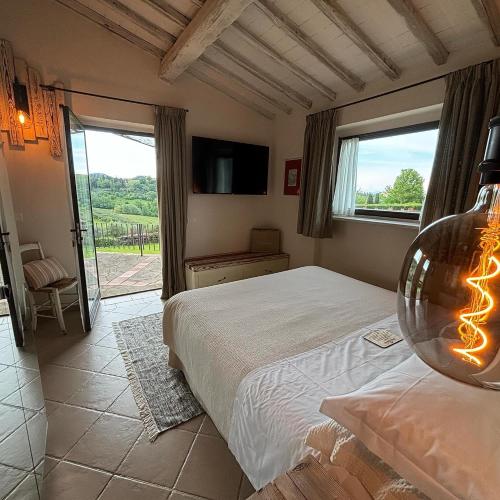 ein Schlafzimmer mit einem Bett und einem großen Fenster in der Unterkunft Podere Bellavista in San Gimignano