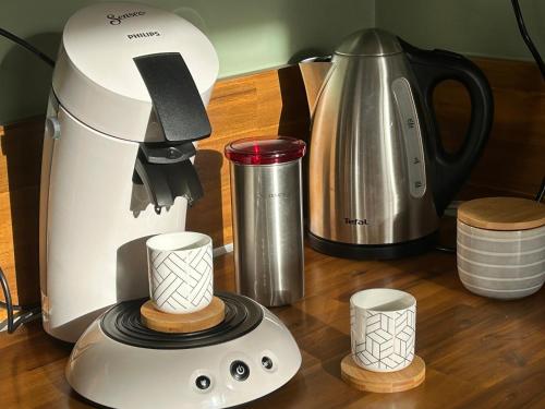 un comptoir de cuisine avec une cafetière et un mixeur dans l'établissement T2 rénové proche des arènes, à Saintes