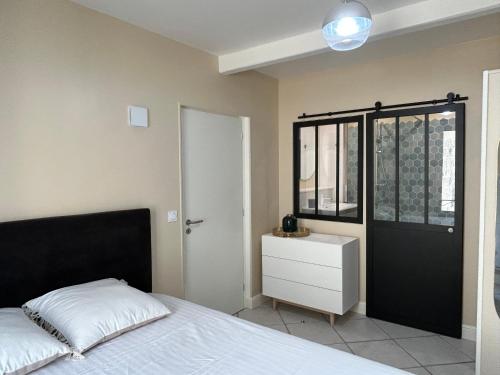 - une chambre avec un lit et une porte noire dans l'établissement T2 rénové proche des arènes, à Saintes