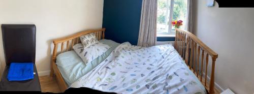 a crib in a room with a bed with a crib sqor at Private Lovely double bedroom in High Wycombe