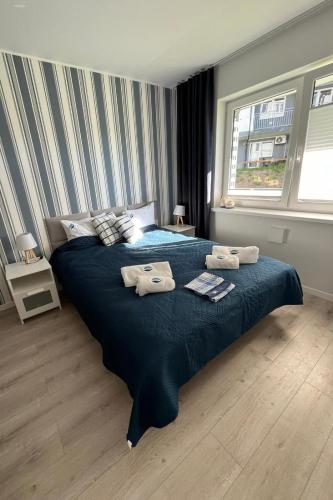 a bedroom with a large bed with towels on it at Apartament Szept Morza in Debina