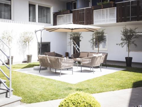 a patio with a table and chairs under an umbrella at Hotel Panorama in Rablà