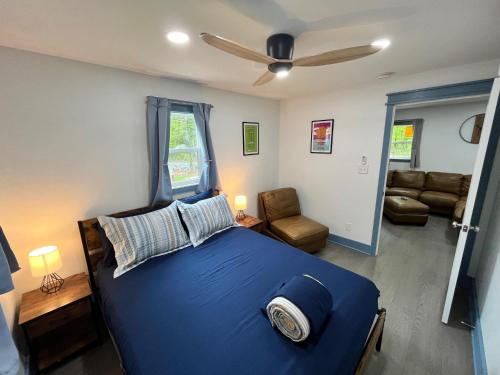 a bedroom with a blue bed and a living room at Bear Run Bungalow in Hawley