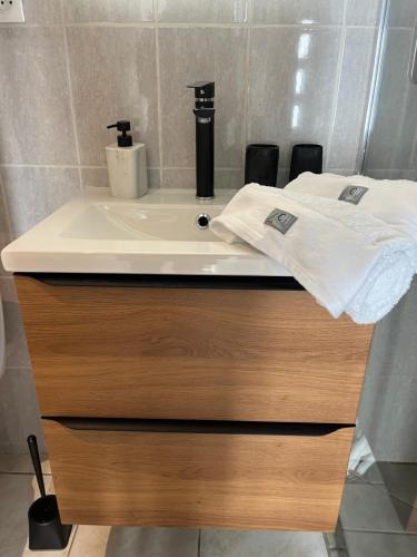 a bathroom sink with two towels on top of it at La maison l escalier des falaises in Sotteville-sur-Mer